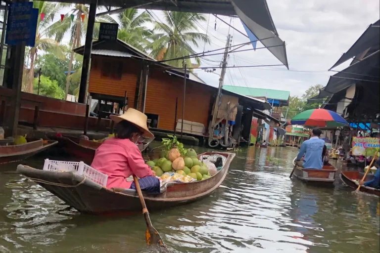 Bangkok et le Centre 12 Vendeuse en chapeau de paille pagayant sa barque chargée de fruits frais au marché flottant près de Bangkok
