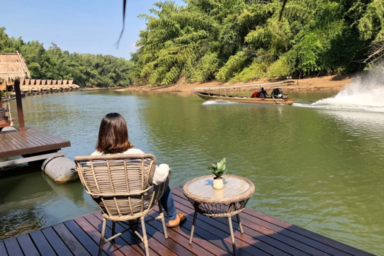 Voyageuse contemplant la rivière Kwaï depuis un radeau-hôtel flottant dans la jungle de Kanchanaburi