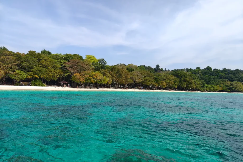 Plage de sable blanc bordée de forêt tropicale et eaux turquoise à Koh Rok, île inhabitée des îles de Trang