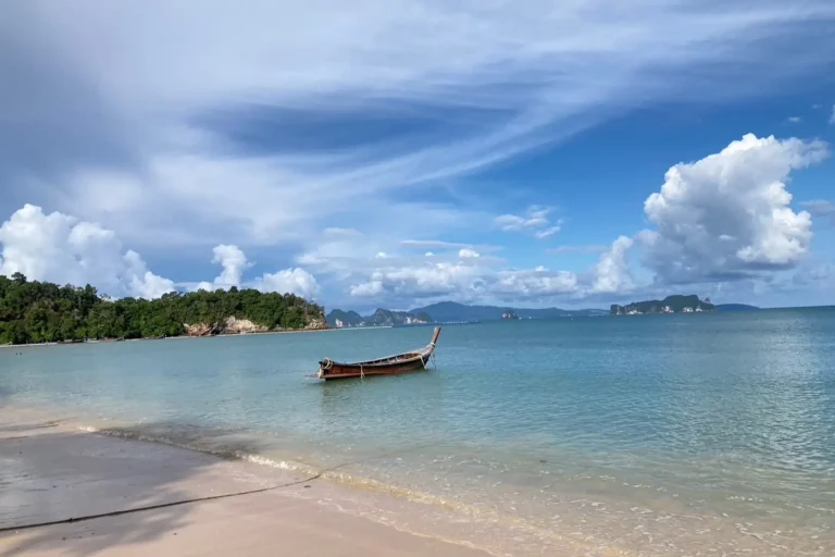 Long-tail boat amarré sur la plage déserte de Koh Yao Noi, baie de Phang Nga en arrière-plan