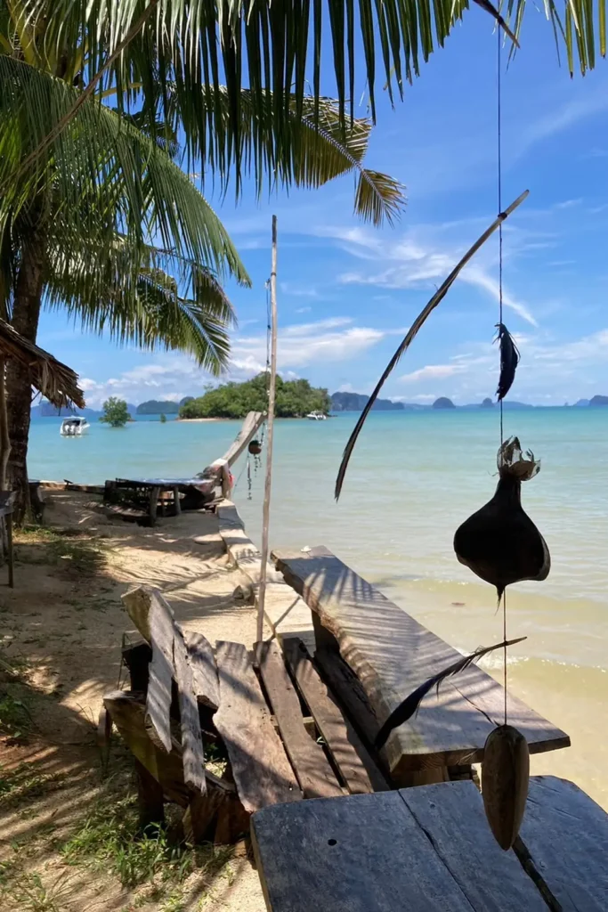 Terrasse rustique sous les cocotiers à Koh Yao Noi, avec vue sur la baie de Phang Nga et ses îlots