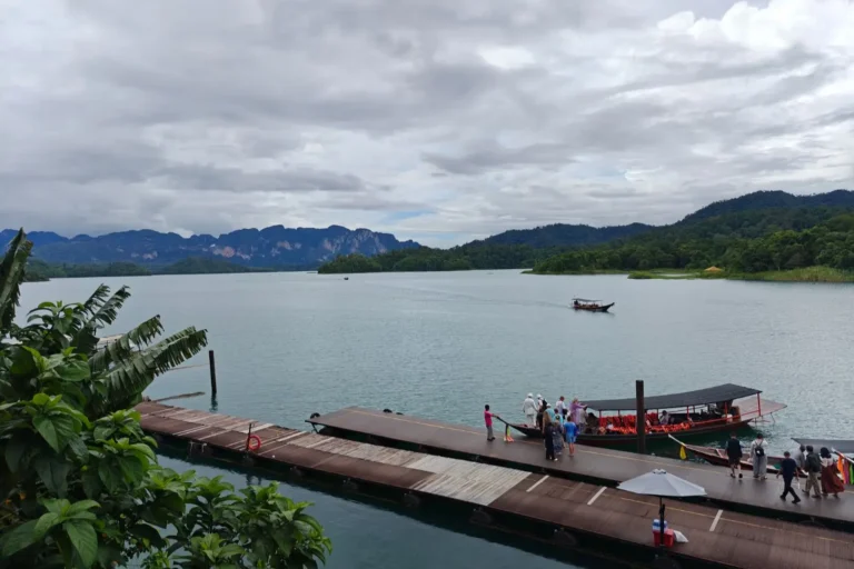 Embarcadère du port du lac de Cheow Lan, ciel nuageux, un groupe de touriste embarque pour une excursion en longtail.
