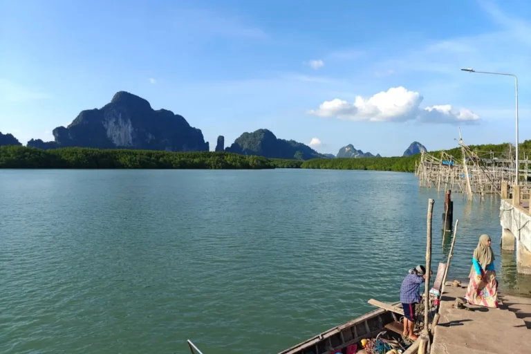 Pêcheurs sur le quai de Laem Sak au lever du jour, mangroves et pitons karstiques de la baie de Phang Nga en fond