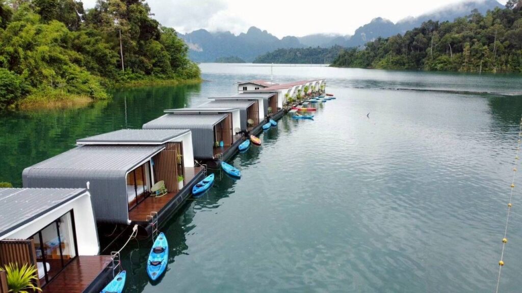 Vue aérienne d'une rangée de bungalow flottants avec kayaks privés amarrés sur le lac de Cheow Lan, Khao Sok.