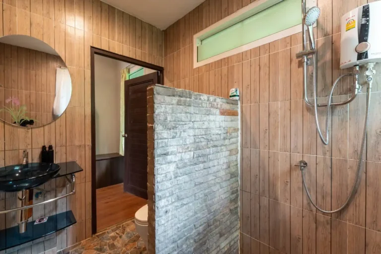 Essence du Sud 17 Salle de bain privative du bungalow Rock & Tree House avec douche à l'italienne, lavabo suspendu et carrelage imitation bois, confort nature pour une excursion Khao Sok