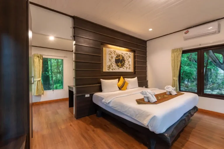 Essence du Sud 15 Chambre double du bungalow Rock & Tree House avec lit king size, décoration thaïe et grandes fenêtres ouvrant sur la forêt tropicale de Khao Sok
