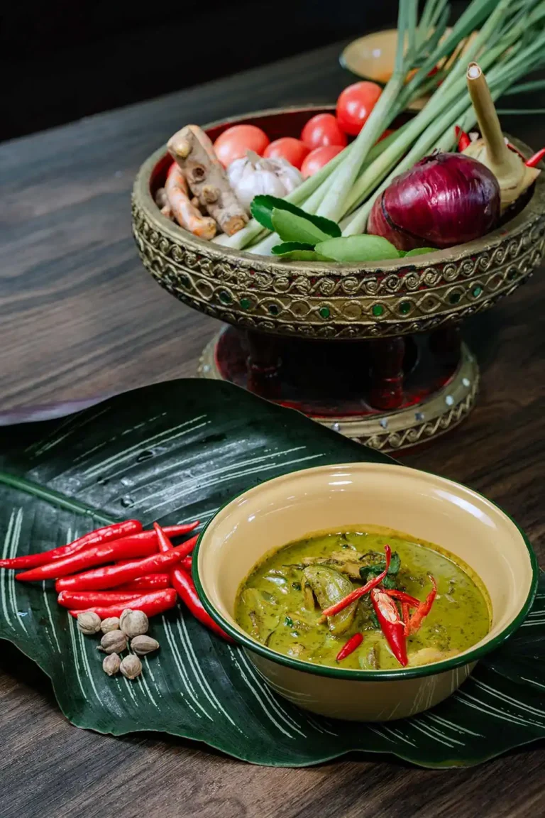 Cours de cuisine thaïlandaise 9 Curry vert thaïlandais maison servi dans un bol sur feuille de bananier, entouré de légumes frais. Cours de cuisine à Ao Nang, Krabi