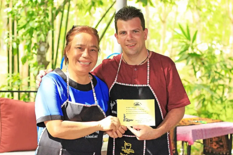 Cours de cuisine thaïlandaise 5 Yaa remettant un certificat à un participant à la fin de son cours de cuisine thaïlandaise à Krabi, souvenir unique du sud Thaïlande
