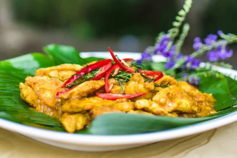 Cours de cuisine thaïlandaise 7 Poulet au curry jaune thaïlandais garni de piments rouges sur feuille de bananier, plat préparé au cours de cuisine de Yaa à Krabi