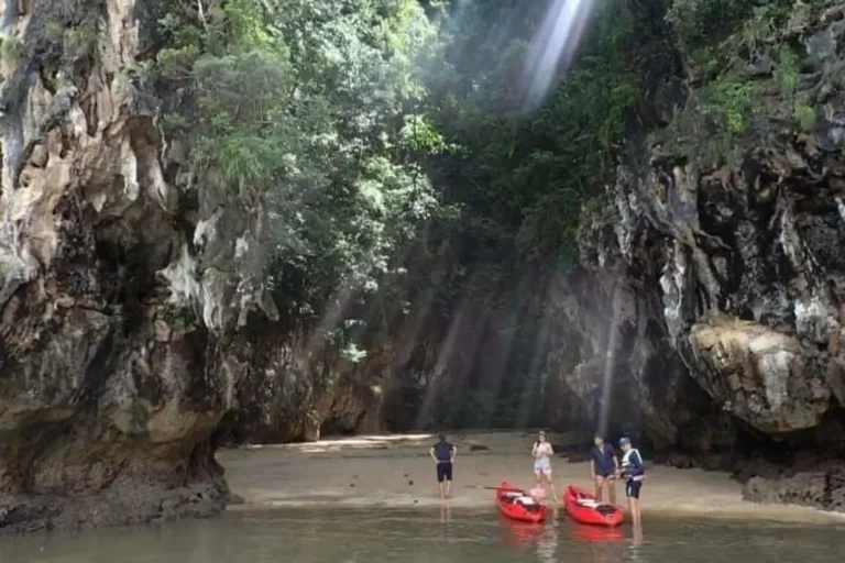 Groupe de kayakistes débarqués dans un canyon baigné de lumière, étape mythique du kayak à Ao Thalane