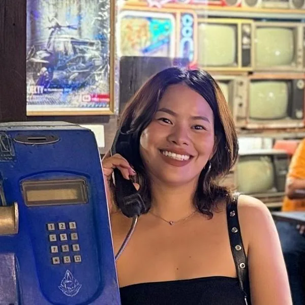 May, de l'équipe Sanuk Voyages, au téléphone dans un café de Krabi