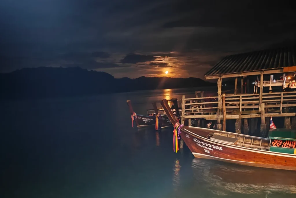 Bateaux longue-queue amarrés au ponton d'un homestay à Koh Jum, pleine lune se levant sur la baie, Thaïlande